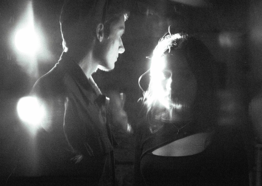 A blurry black and white image of a man & woman in blackx